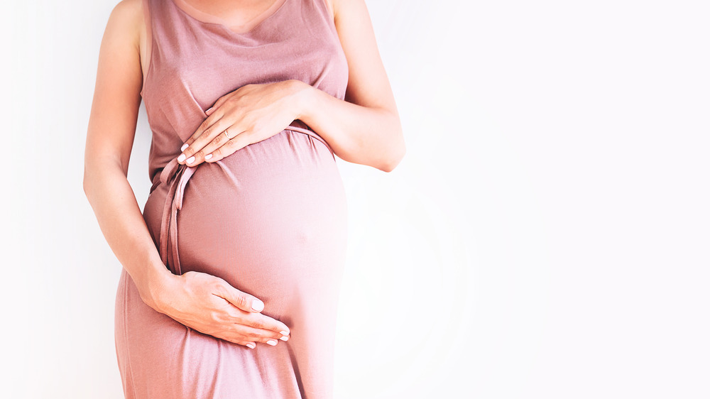 woman holding pregnant belly