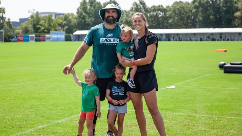 Jason and Kylie Kelce with their three oldest daughters at a football field