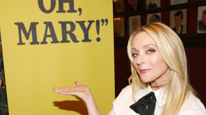 Jane Krakowski posing next to an "Oh, Mary!" poster