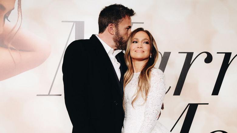 Ben Affleck kisses Jennifer Lopez on the head as they walk a red carpet event