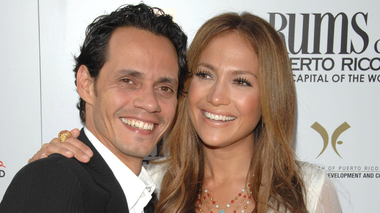 Jennifer Lopez places her hand around Marc Anthony as they smile for a photo