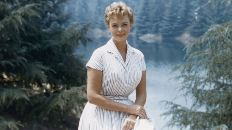 June Lockhart in front of a lake surrounded by trees