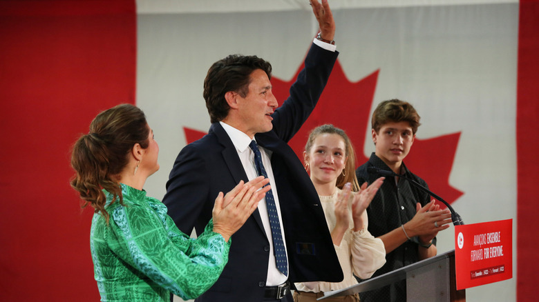 Justin Trudeau standing at a podium and waving with his family standing beside him