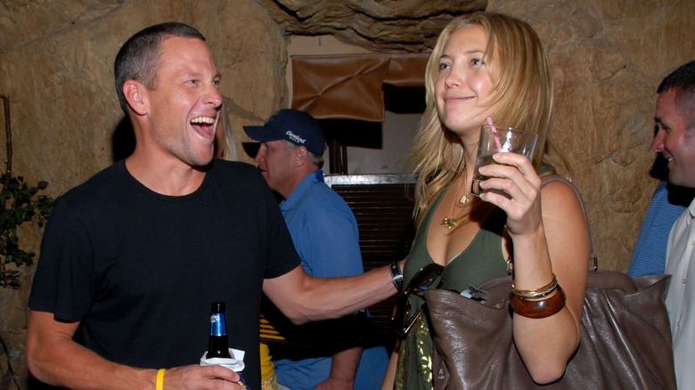 A candid of Lance Armstrong and Kate Hudson having drinks and laughing