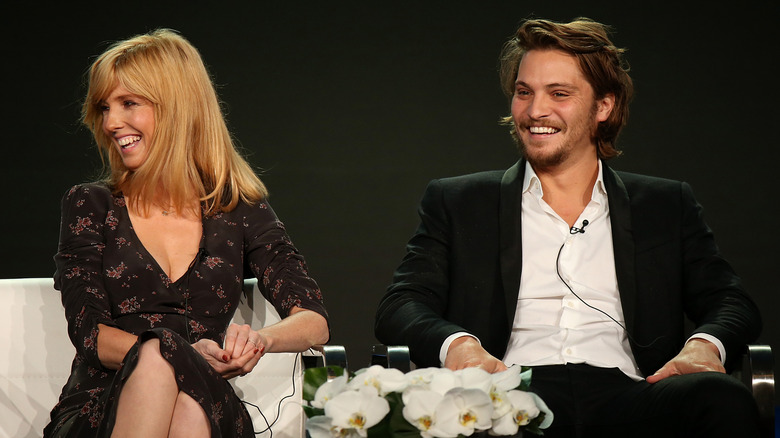 Kelly Reilly and Luke Grimes smiling on a stage during a panel