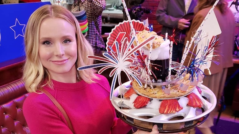 Kristen Bell with a prop on The Good Place set