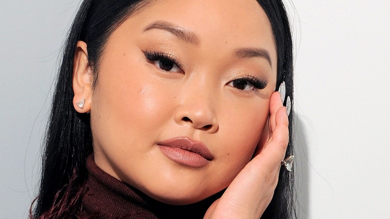 Lana Condor posed with hand on face