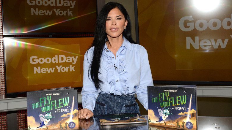 Lauren Sánchez Bezos smiling with copies of her book