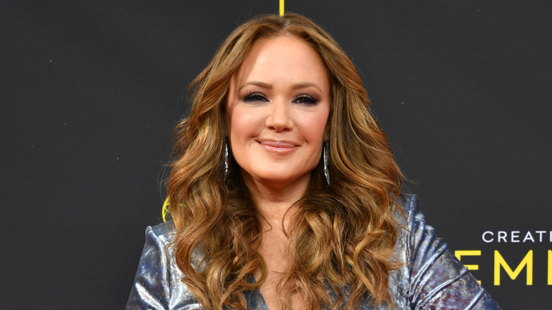 Leah Remini smiles in a silver dress