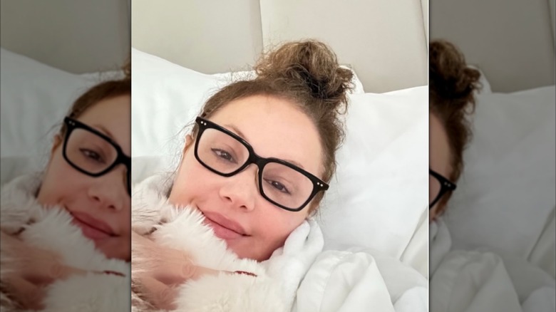 Leah Remini smiles in her bed