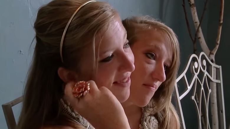 Abby and Brittany Hensel talking to someone on their reality show