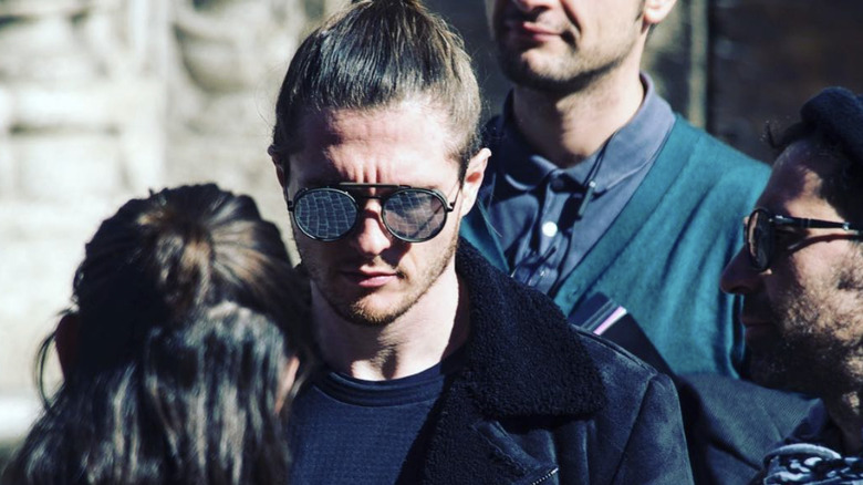 Raffaele Sollecito wearing sunglasses surrounded by people