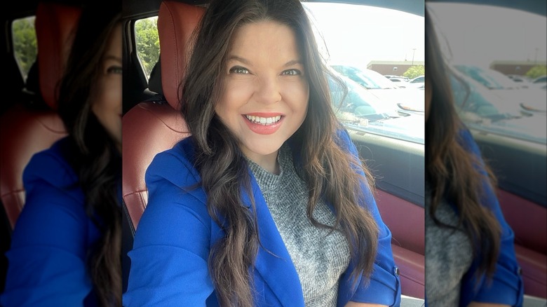 Amy takes a selfie inside a car.