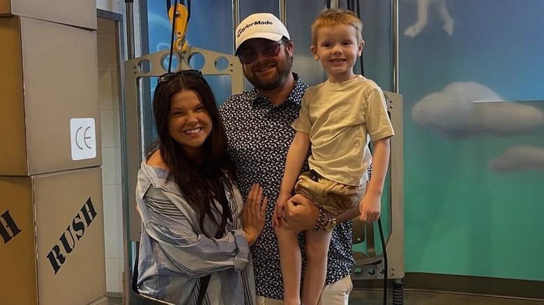 Amy poses with her husband and son