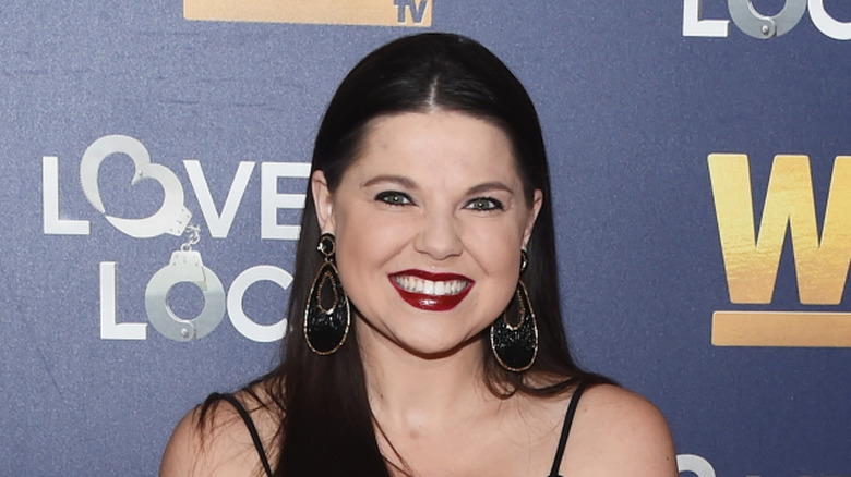 Amy Duggar King smiles on a red carpet