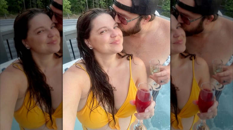 Amy in a bathing suit gets a kiss from her husband.