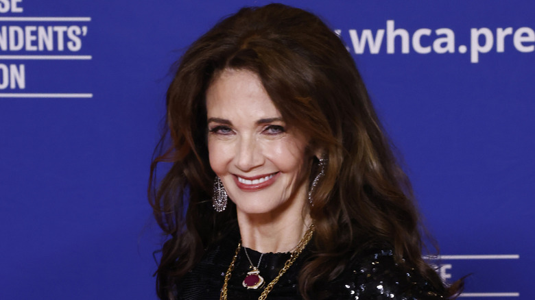 Lynda Carter smiles while posing in a black sequined outfit
