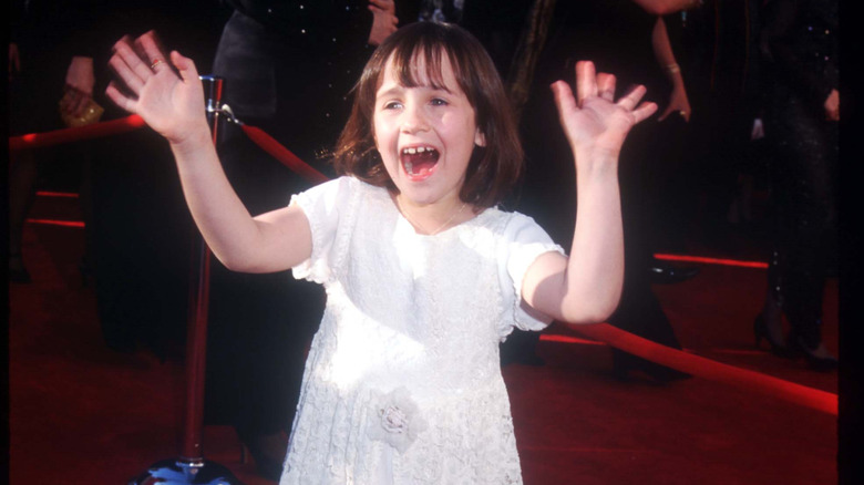 Mara Wilson waving and smiling on the red carpet.