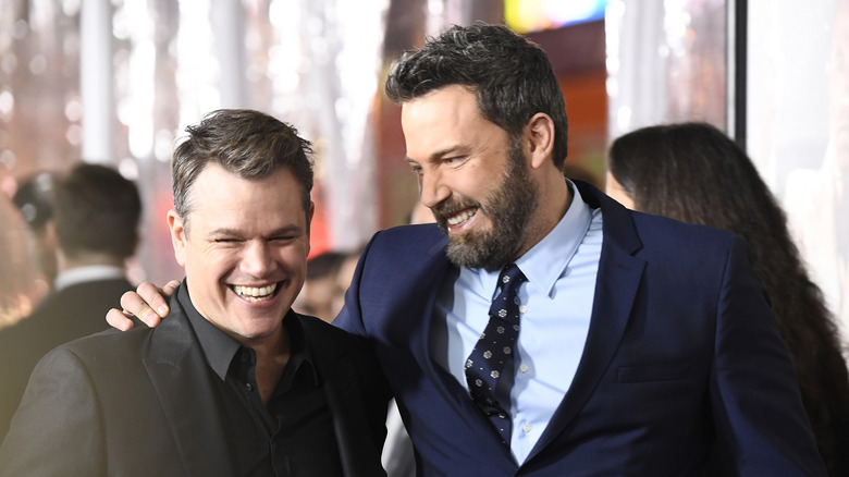 Ben Affleck smiling at Matt Damon with arm around his shoulder