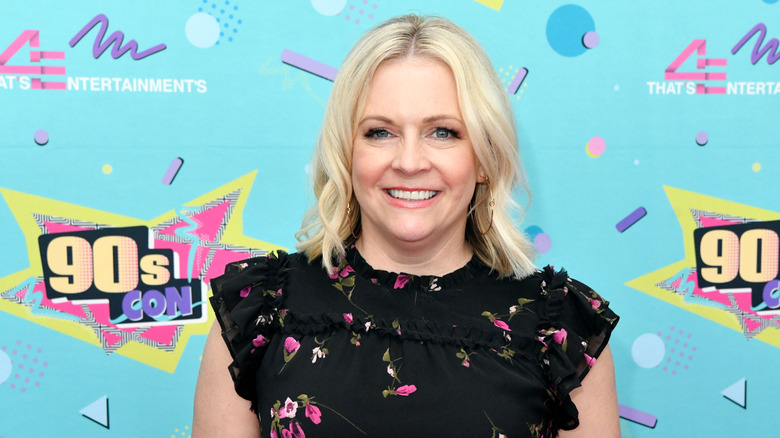 Melissa Joan Hart wearing a black dress with floral print