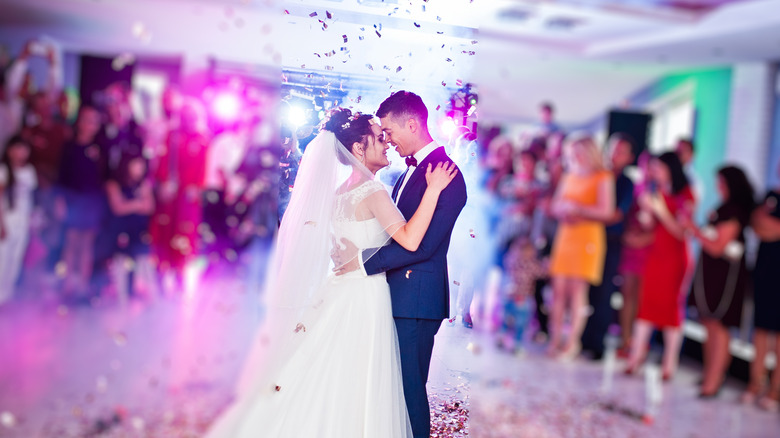 Married couple dances as guests surround them