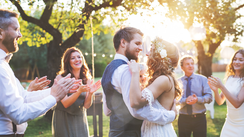 Married couple smiles as guests around them clap