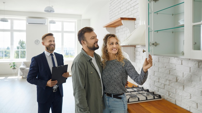 Couple looking at house with real estate agent