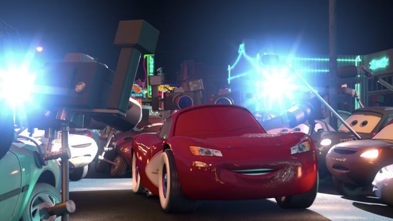 Lightning McQueen surrounded by photographers in "Cars"