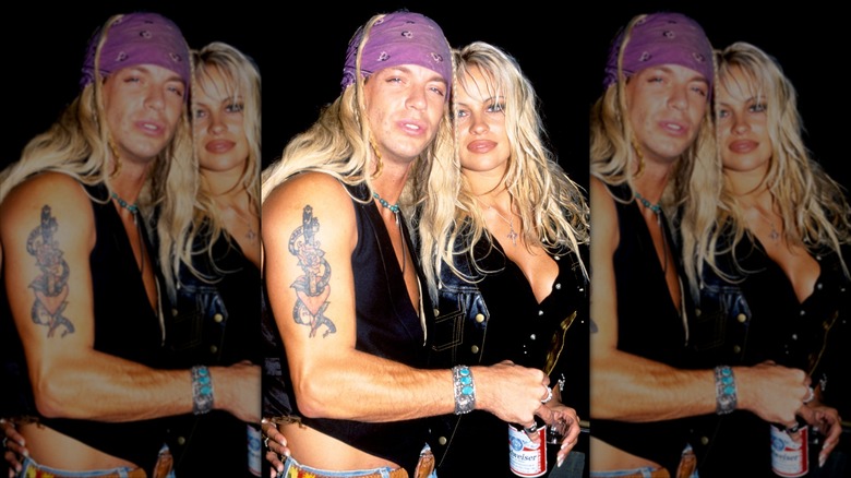 Bret Michaels and Pamela Anderson posing together with a bottle of Budweiser.