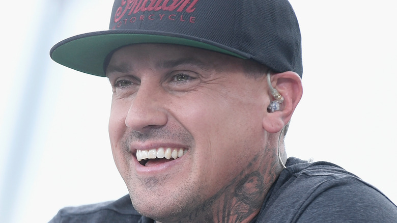 Carey Hart smiling in hat