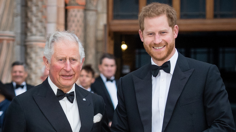 King Charles III and Prince Harry in tuxedos smiling