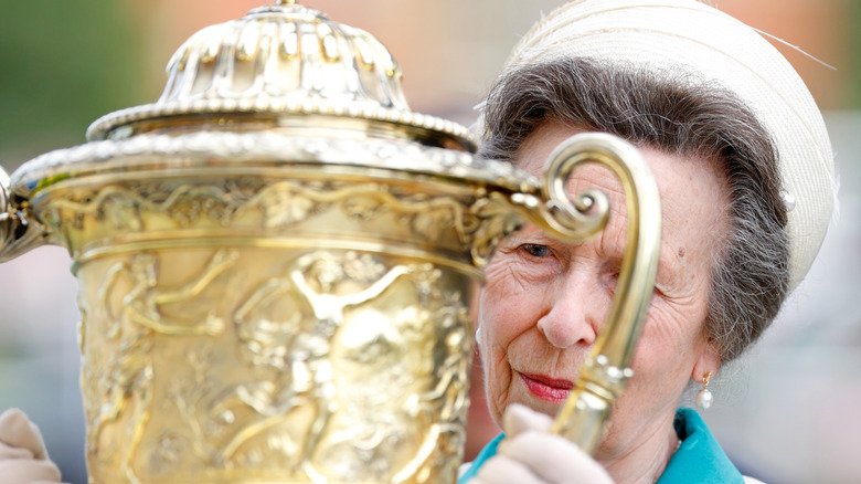 Princess Anne holding a giant trophy
