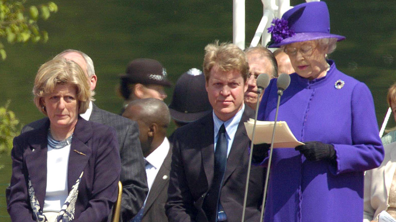 Queen Elizabeth speaking while Spencer family watches