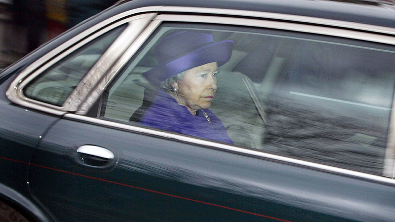 Queen Elizabeth wearing purple in a car