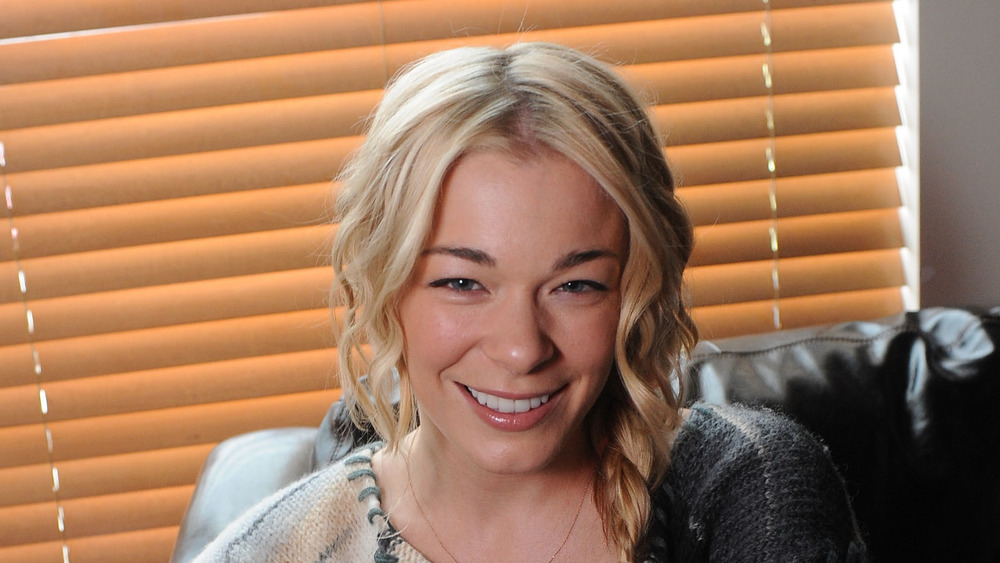 LeAnn Rimes sitting in front of blinds