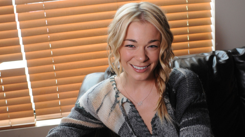 LeAnn Rimes sitting in front of blinds