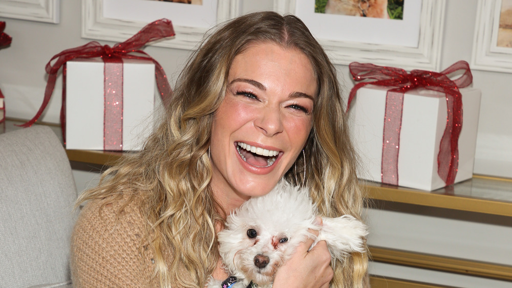LeAnn Rimes holding a dog, grinning