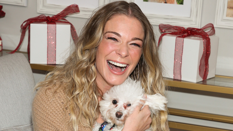 LeAnn Rimes holding a dog, grinning