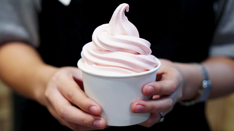Person holding frozen yogurt cup