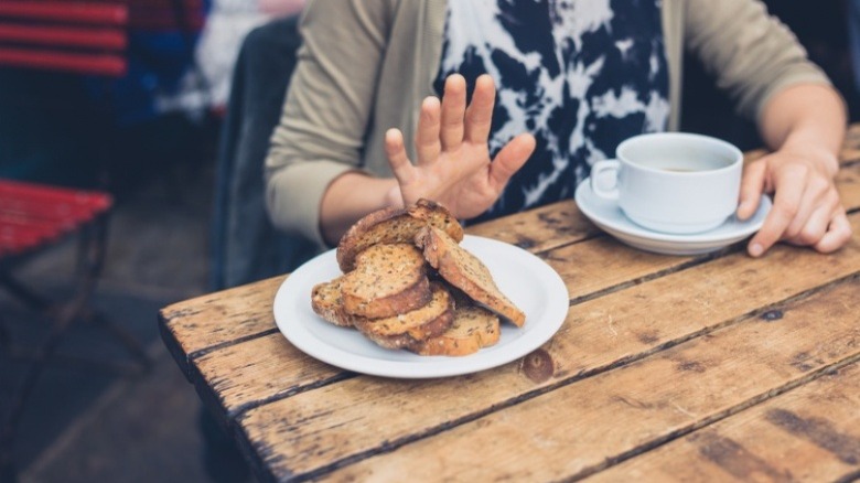 woman pushing away bread