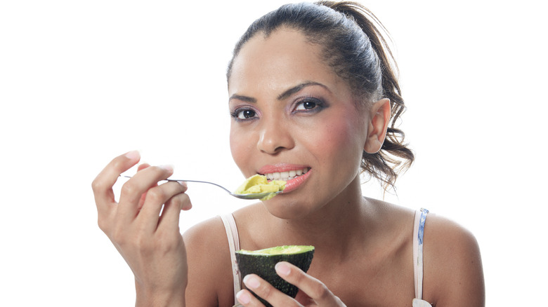 Woman eating avocado