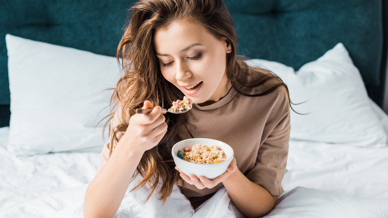 Woman eating oatmeal in bed