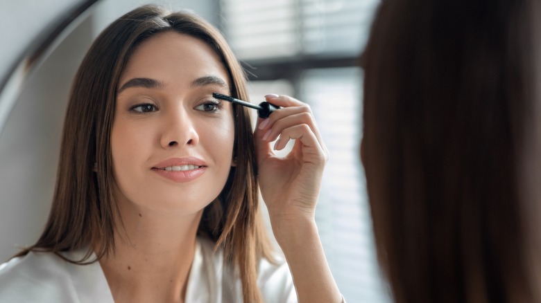 Woman applying mascara