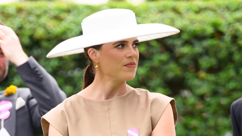 Princess Eugenie outside in a beige dress and big white hat