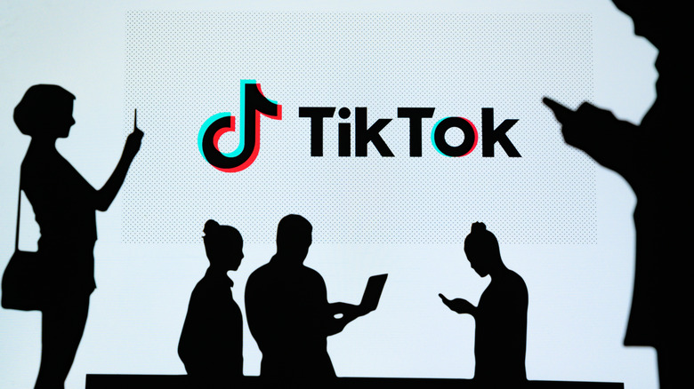 TikTok logo and a silhouettes people looking at their phones.