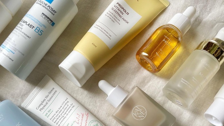 Assortment of skincare products on white cloth