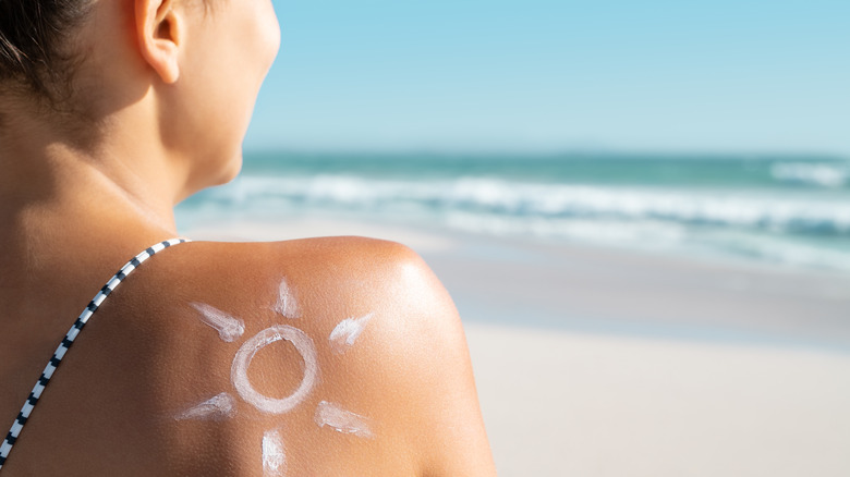 Woman using sunscreen at ocean
