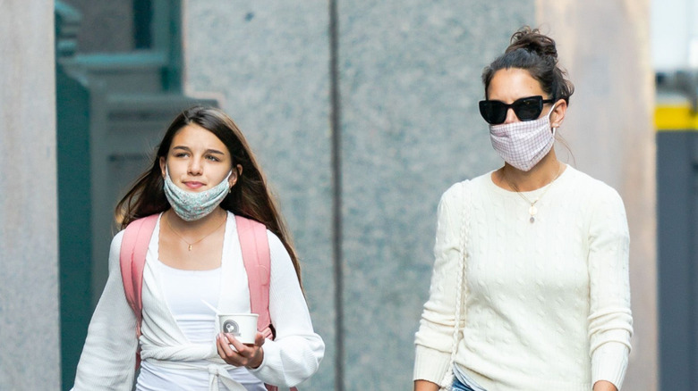 Suri Cruise and Katie Holmes walking wearing face masks