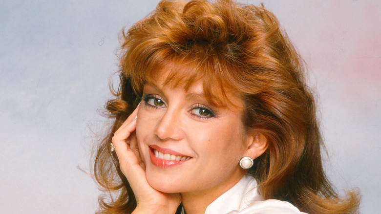 A photo of Victoria Principal with her head in her hand