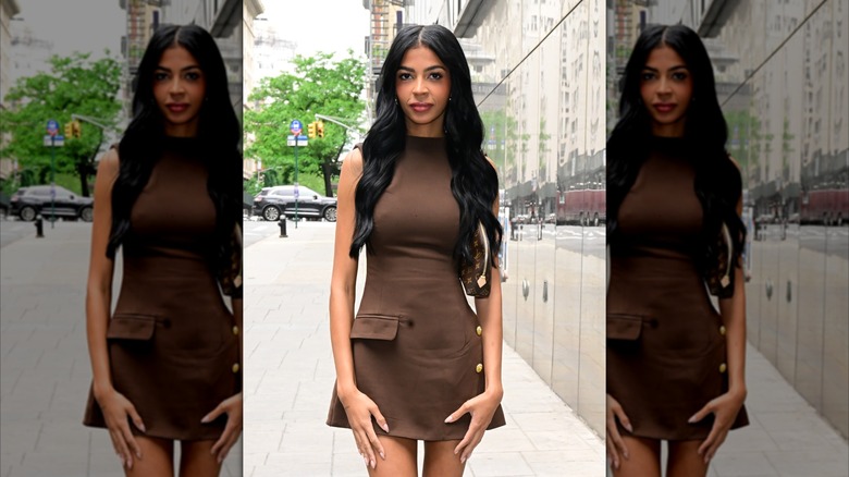 Layla Taylor posing in a brown minidress on a Manhattan sidewalk.